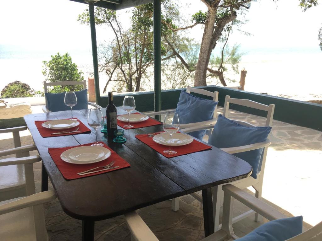 a wooden table with wine glasses and red napkins at Diani Beachalets in Diani Beach