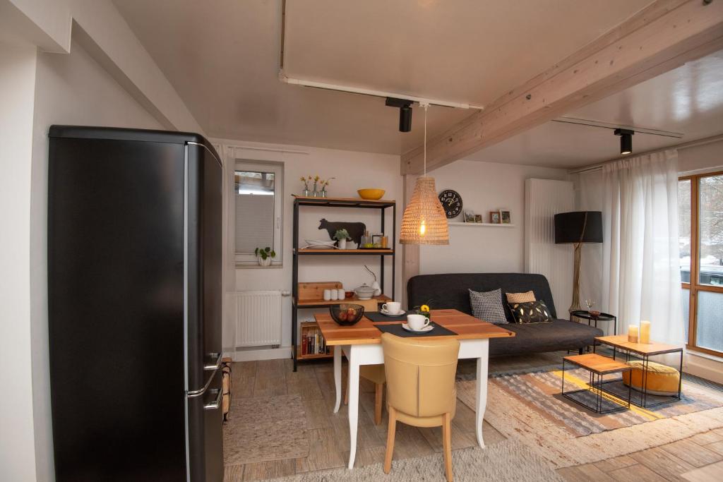 a kitchen and living room with a black refrigerator at Ferienwohnung Eliese in Suhl in Suhl