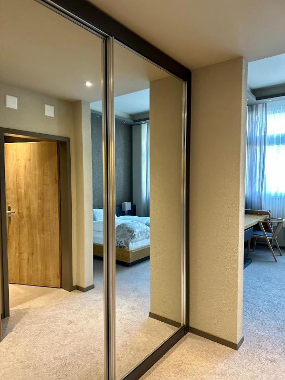 a room with a bedroom with a bed and a mirror at Plaza Hotel Winterthur in Winterthur