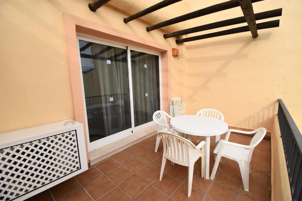 balkon z białym stołem i krzesłami w obiekcie Studio Apt Walking Distance to Beach Wyndham Resor w mieście Mijas Costa