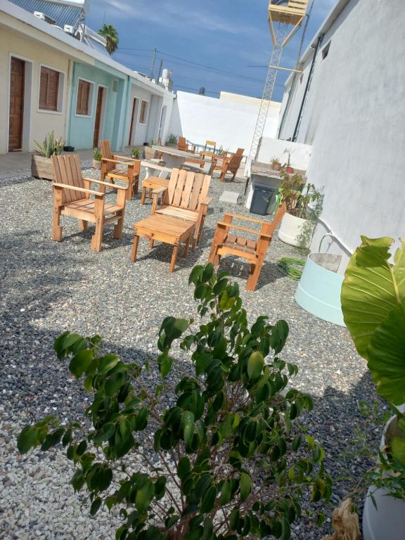 a group of wooden chairs and tables on a patio at APART PIEDRAS,Cochera,Desayuno seco 3 5 3 5 6 3 4 5 1 4 in Villa María