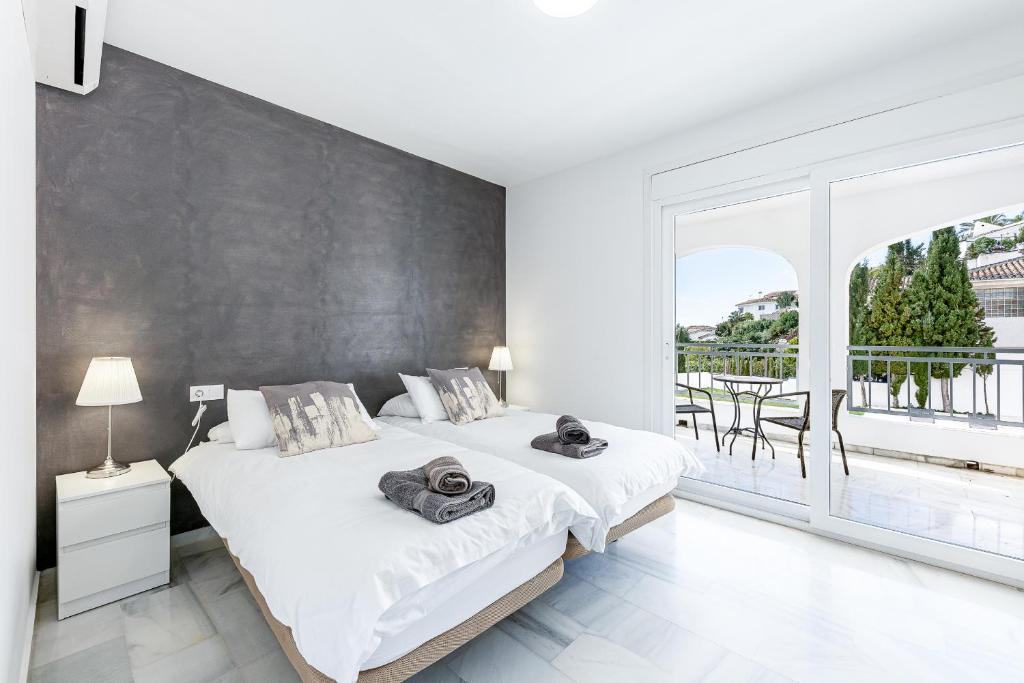 sypialnia z dużym łóżkiem i dużym oknem w obiekcie Luxury villa with Private Pool Benalmadena w mieście Benalmádena