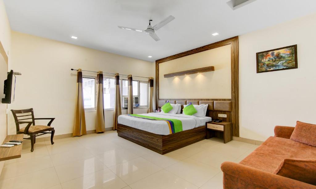 um quarto com uma cama, uma cadeira e um sofá em Raj Darbar - 10 Meter From Golden Temple em Amritsar