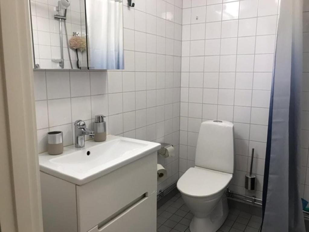 a white bathroom with a toilet and a sink at Casa South in Stockholm