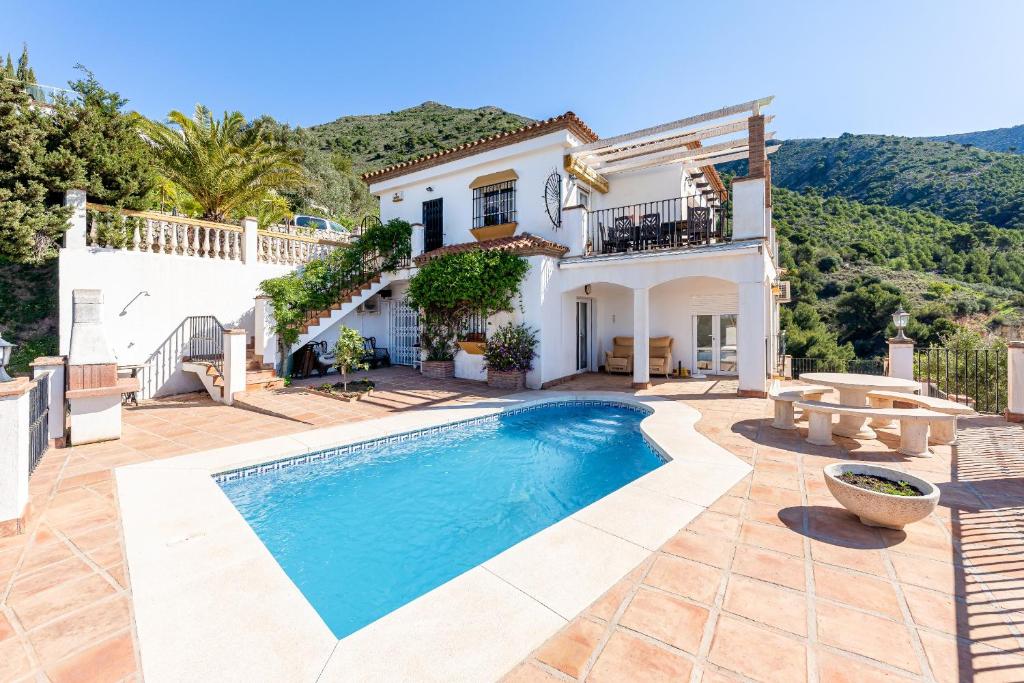 a villa with a swimming pool in front of a house at Villa with Stunning Views & Private Pool in Mijas Costa