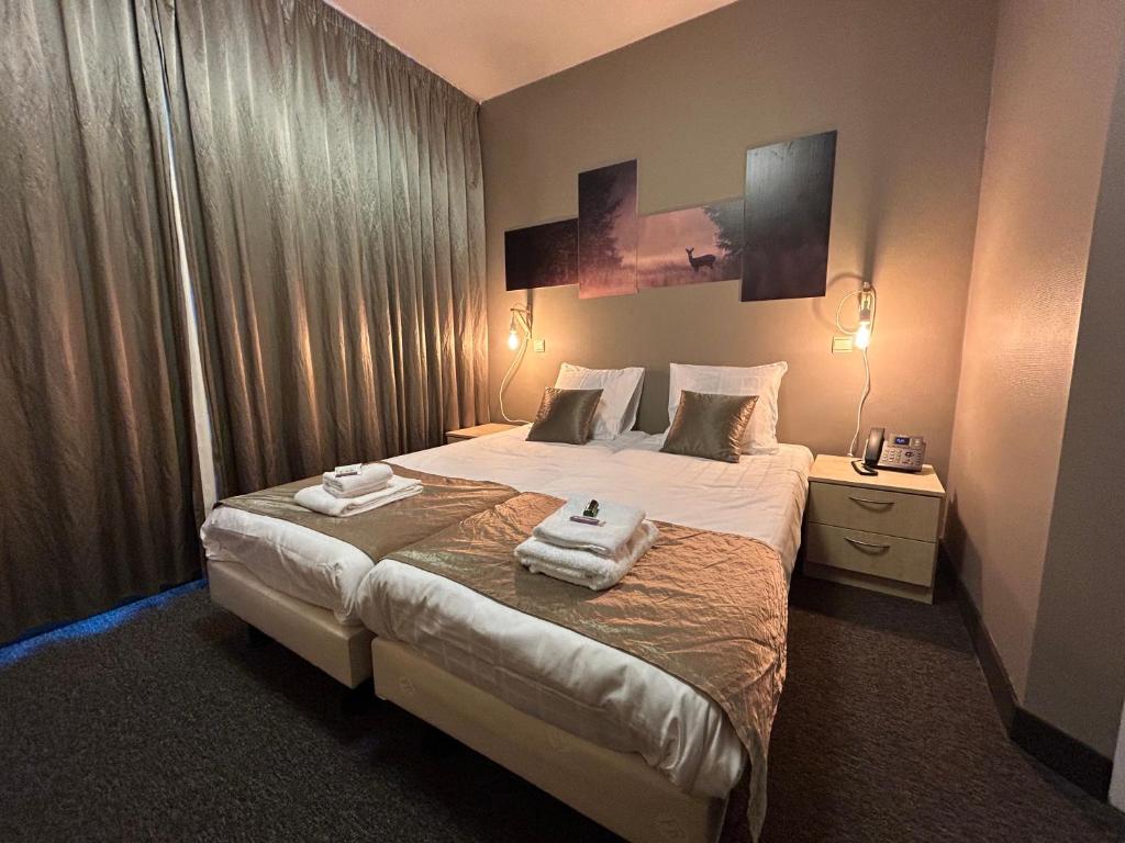 una camera d'albergo con un letto e asciugamani di Floréal a Malmedy