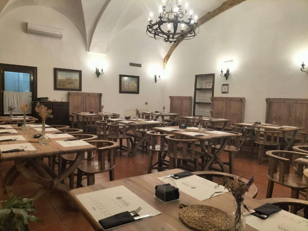 a large room with wooden tables and chairs at Hotel Tugasa Convento San Francisco in Vejer de la Frontera