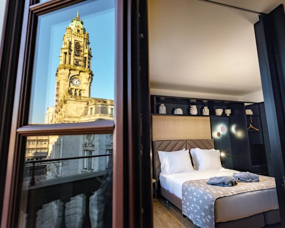 a bedroom with a bed and a clock tower at Axis Porto Club Aliados in Porto