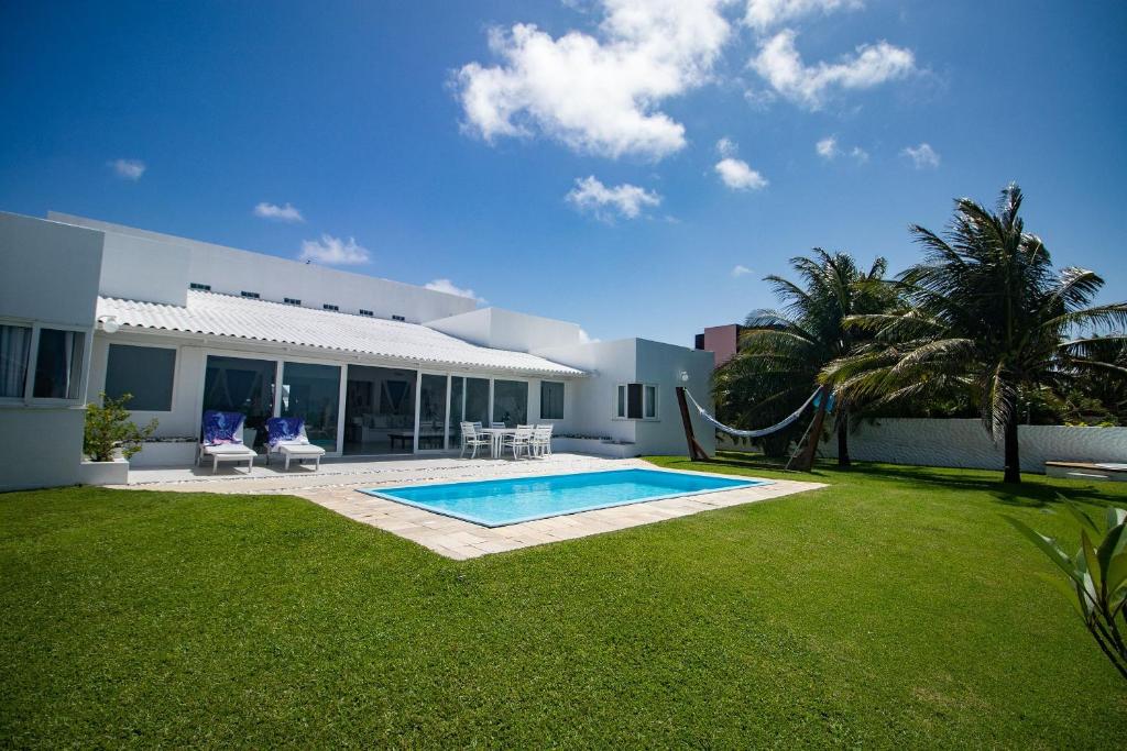 Ceará-Mirim的住宿－Casa Incrível na Praia de Jacumã por Carpediem，一个带游泳池和房子的后院