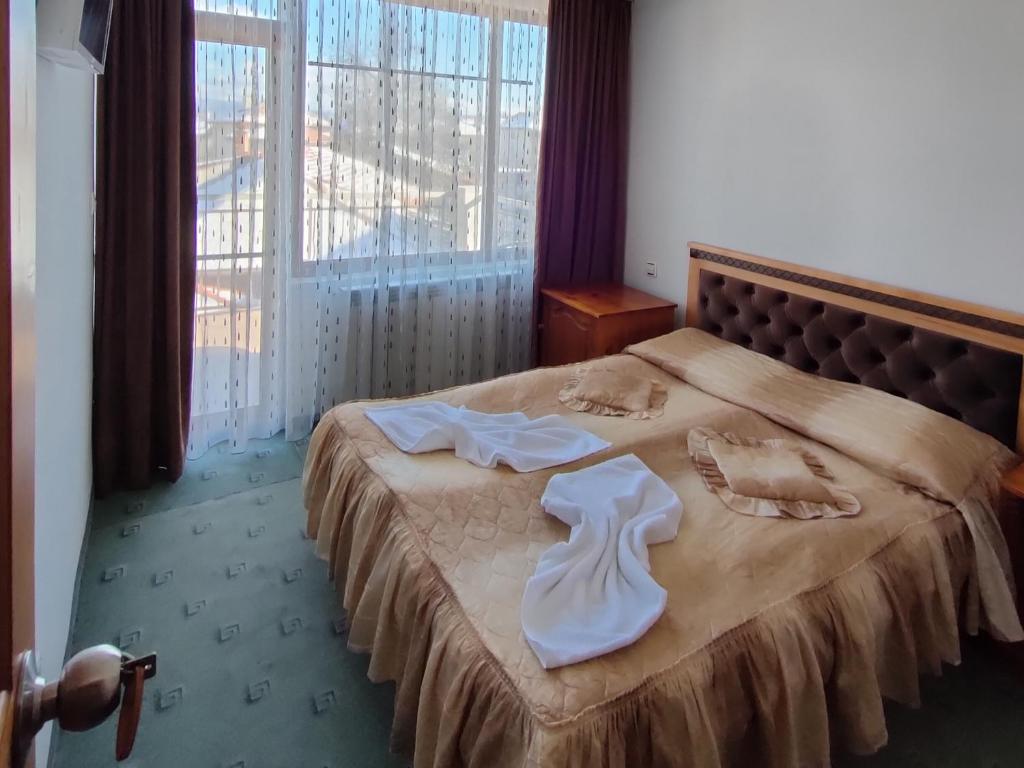 a hotel room with a bed with towels on it at Guest Rooms Grachenovi in Bansko
