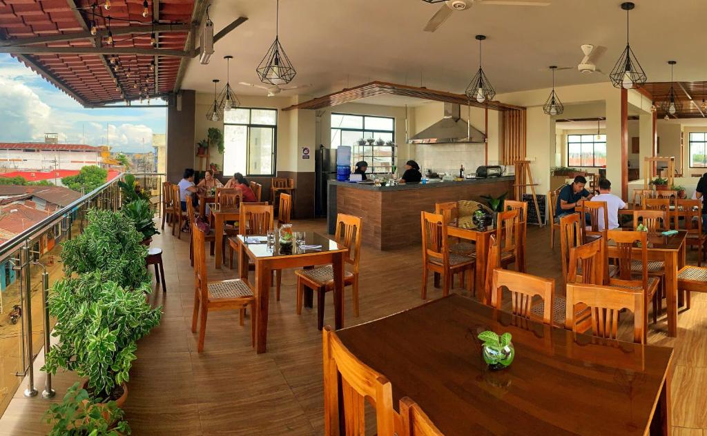 a restaurant with wooden tables and chairs and a counter at Studio 69 Aparthotel in Iquitos