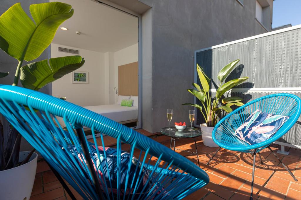 a balcony with two blue chairs and a tub at SmartRoom Barcelona in Barcelona