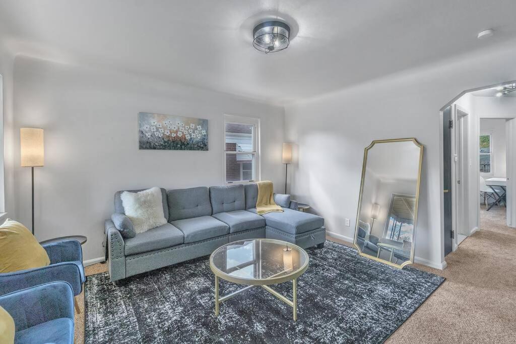 a living room with a blue couch and a mirror at 10 Minutes from Metro Airport! Parking on Premises in Allen Park