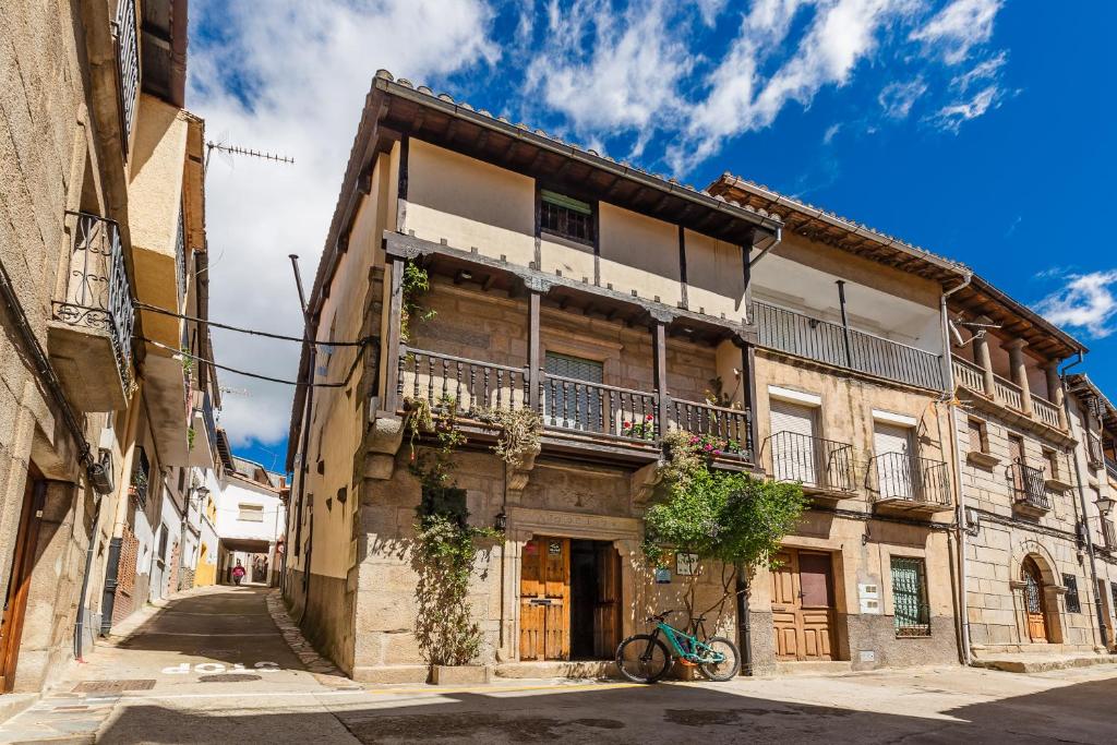 um edifício antigo com uma bicicleta estacionada em frente em Antigua Posada, Valle del Jerte em Tornavacas