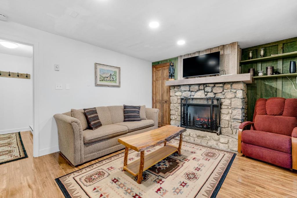 un salon avec un canapé et une cheminée dans l'établissement Briarcliff E24, à Sugar Mountain
