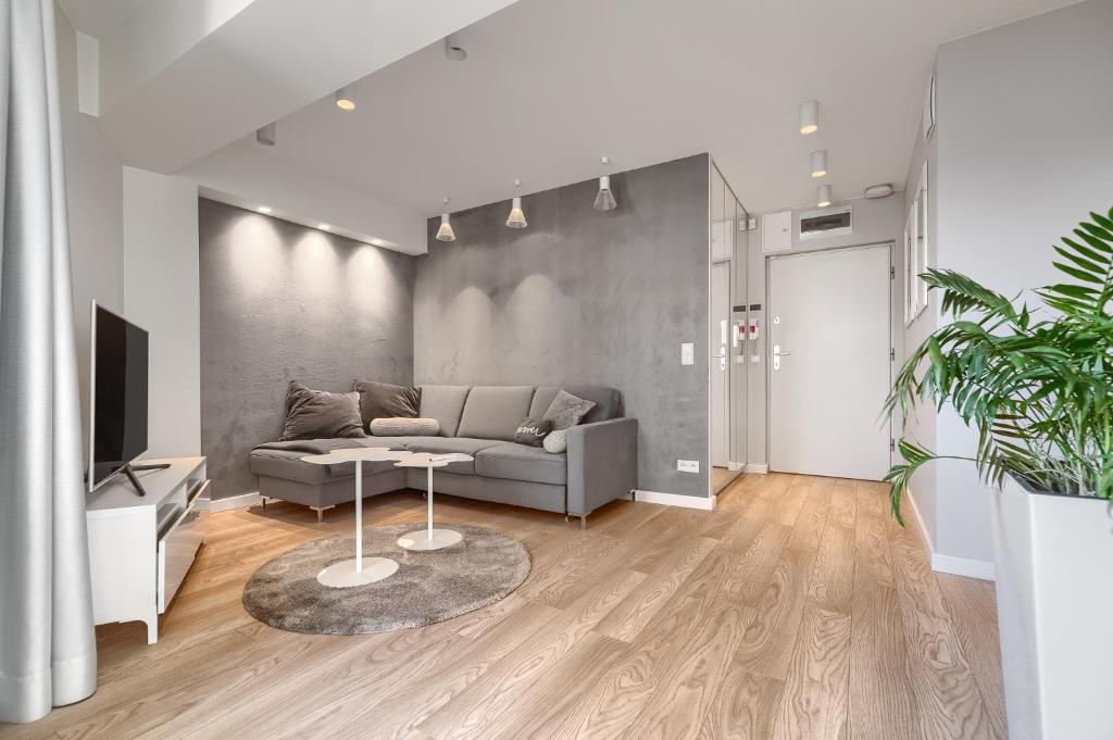 salon z kanapą i stołem w obiekcie Apartamenty MUNN 6 Szczecin w Szczecinie