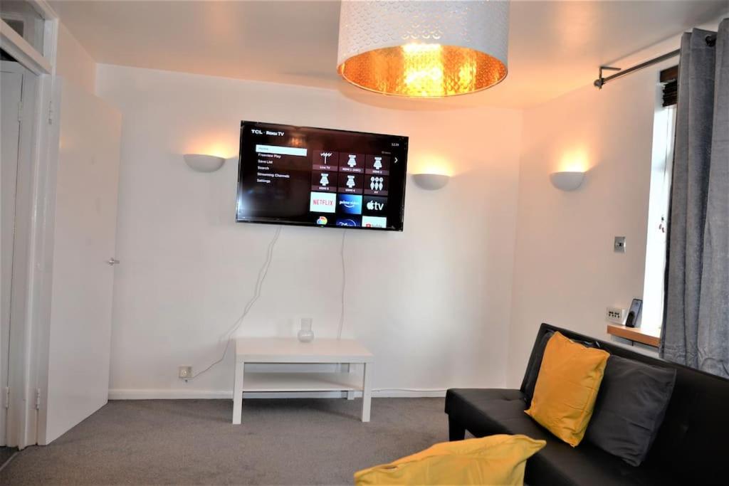sala de estar con sofá y TV en la pared en London Zone 2, 2 Bedroom House, en Londres