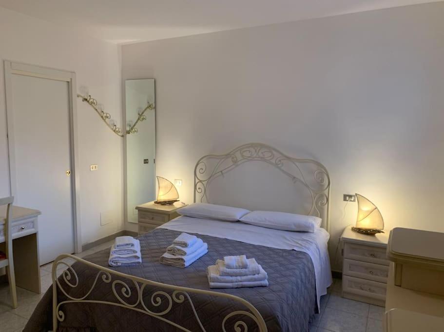 - une chambre avec un grand lit et des serviettes dans l'établissement Villa dei Gelsi, à Leporano Marina