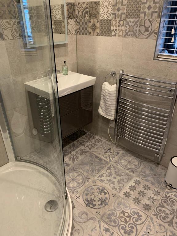 a bathroom with a shower and a sink at Old Manse Cottage in Durness