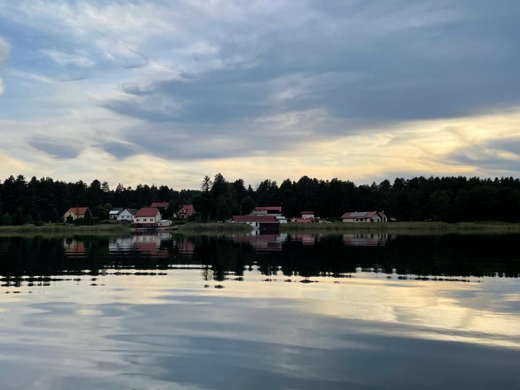 a large body of water with houses in the background at Domy nad jeziorem in Bogaczewo