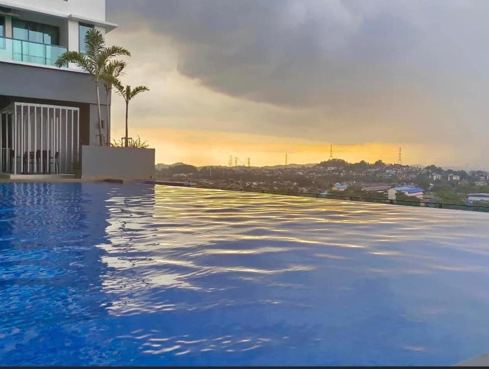 una piscina con tramonto sullo sfondo di Casa Nabila Bandar Baru Bangi a Bangi