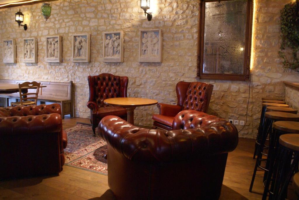a bar with leather chairs and a table and a couch at Domaine Utah Beach - Le Grand Hard in Sainte-Marie-du-Mont