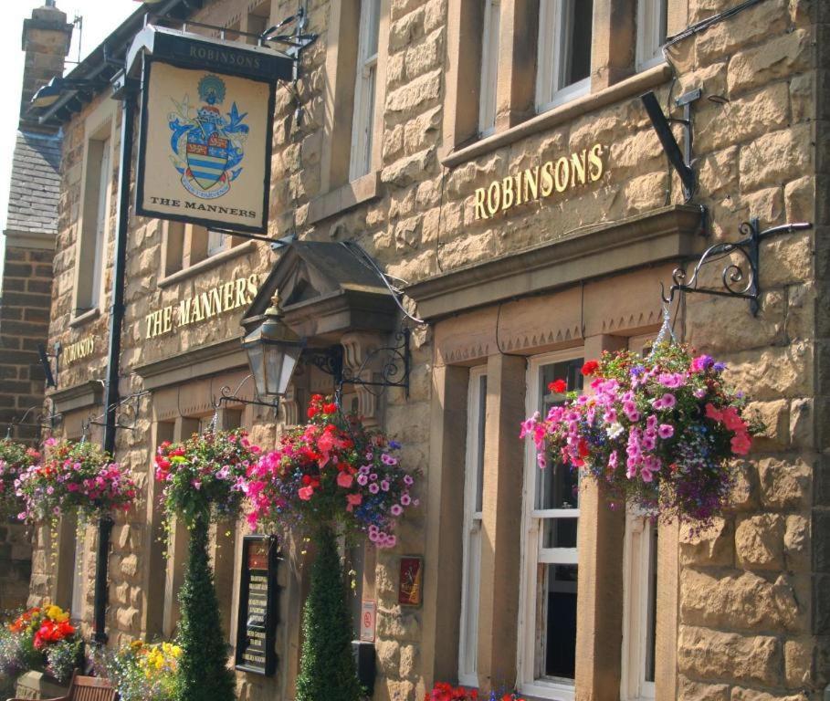 a building with flower boxes on the front of it at The Manners Pub with Rooms in Bakewell