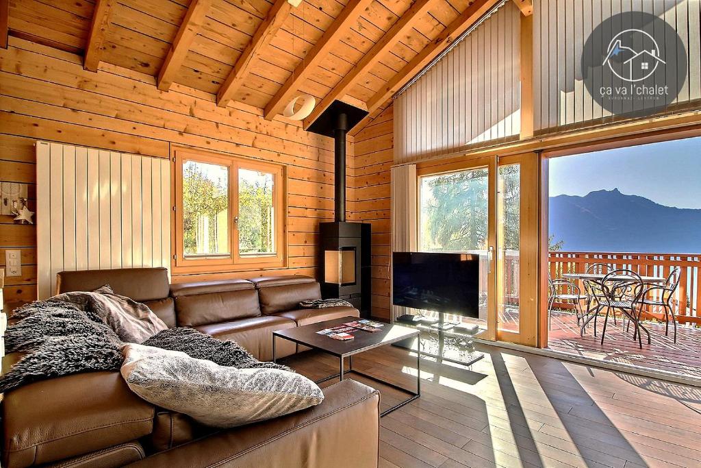 a living room with a couch and a television in a cabin at L'Eden in Ovronnaz
