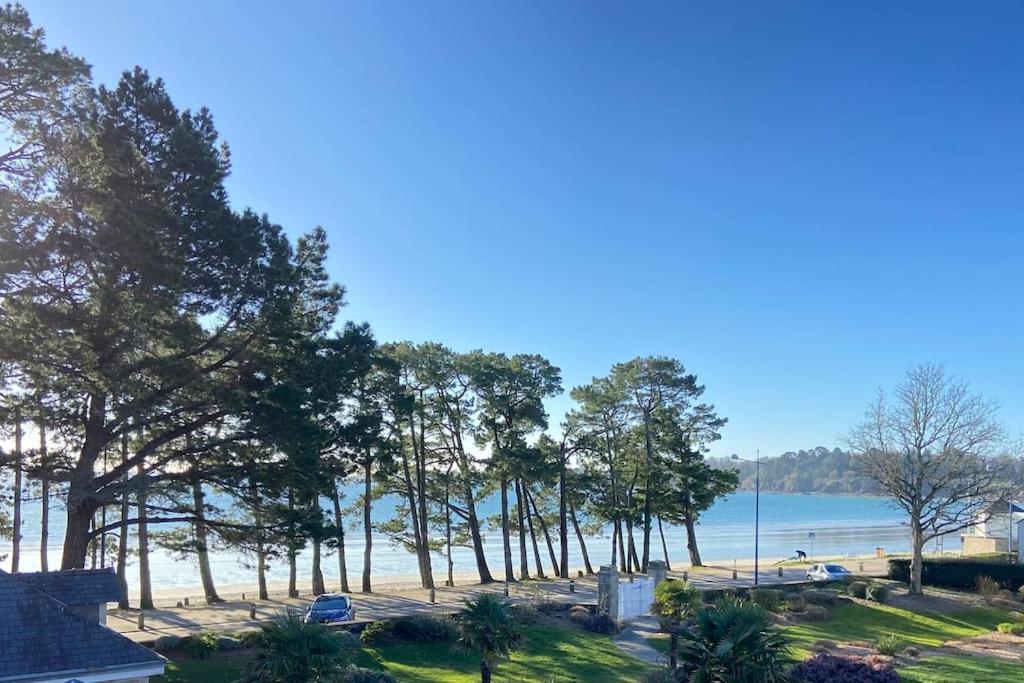 a view of a beach with trees and the water at Grand Appartement duplex vue mer in Fouesnant