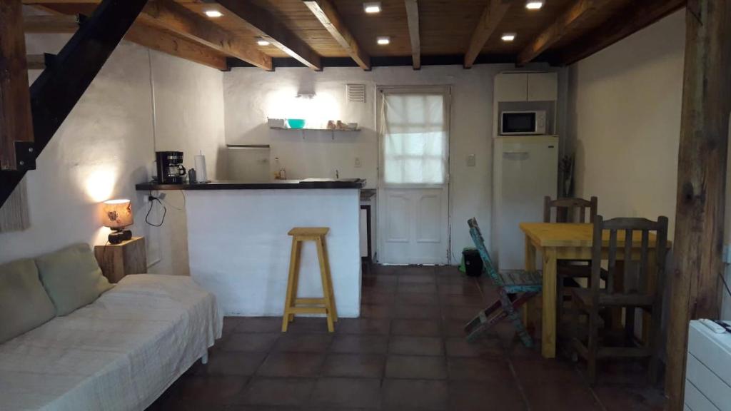 a living room with a couch and a kitchen at COMPLEJO DRUMMOND en el Camino del Vino in Ciudad Lujan de Cuyo