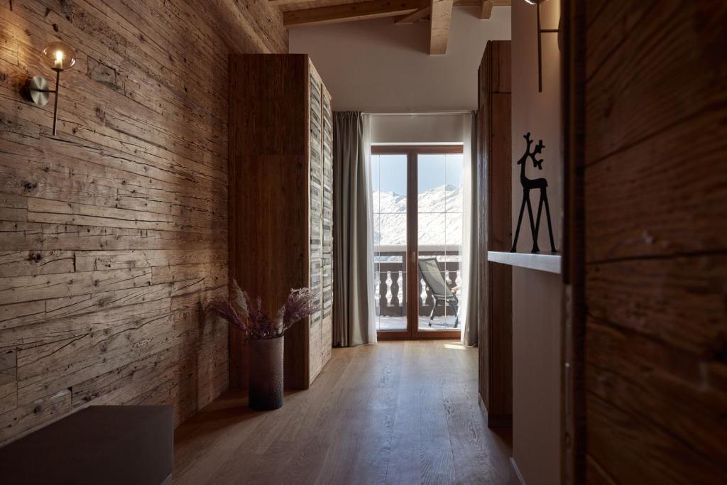 a hallway with a wooden wall and a door with a window at TOP Hotel Hochgurgl in Hochgurgl