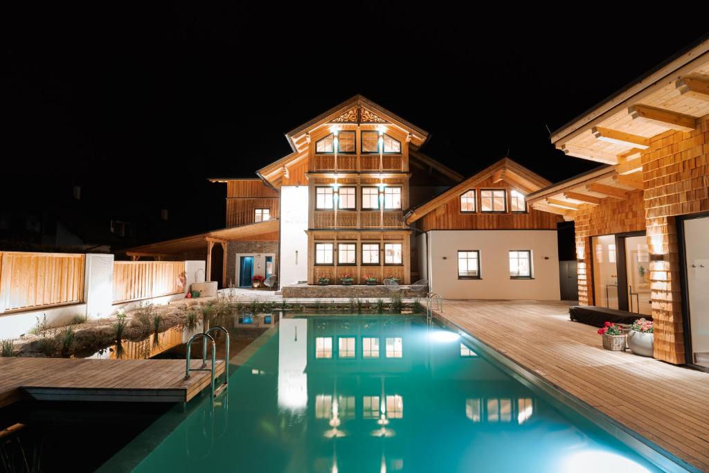 a house with a swimming pool at night at DAS SALZBERG Hideaway Bad Aussee - Adults only in Bad Aussee