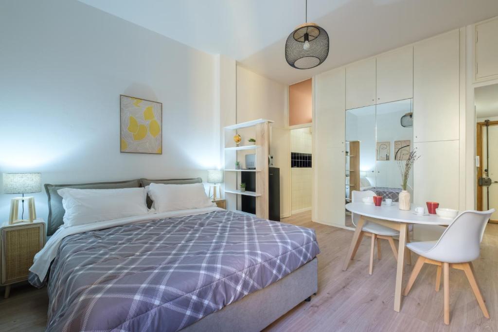 1 dormitorio con 1 cama, mesa y sillas en Casa del Laureato by Studio Vita, en Bolonia
