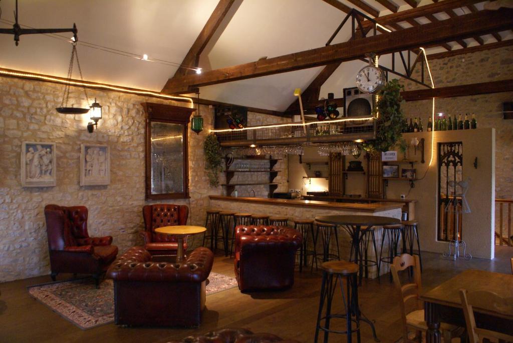 a bar with chairs and tables in a room at Domaine Utah Beach - Le Grand Hard in Sainte-Marie-du-Mont