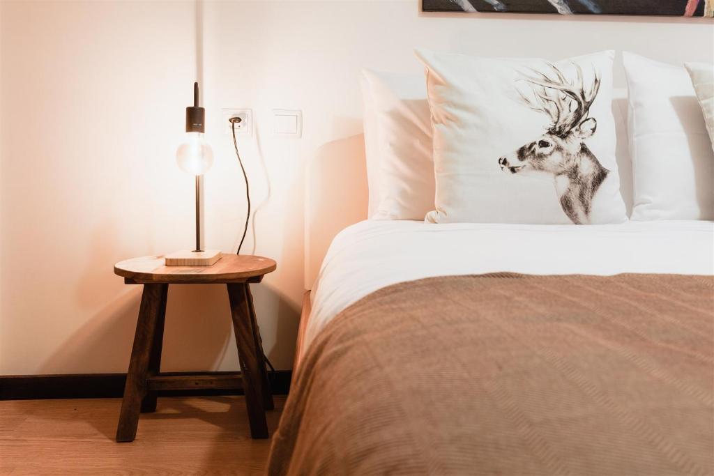 um quarto com uma cama com uma cabeça de veado na almofada em Sunshine Beach Apartment em Leiria
