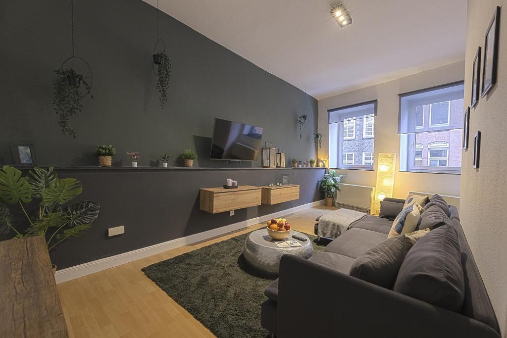 a living room with a couch and a tv at The Harbour Apartment 1 in Hamburg