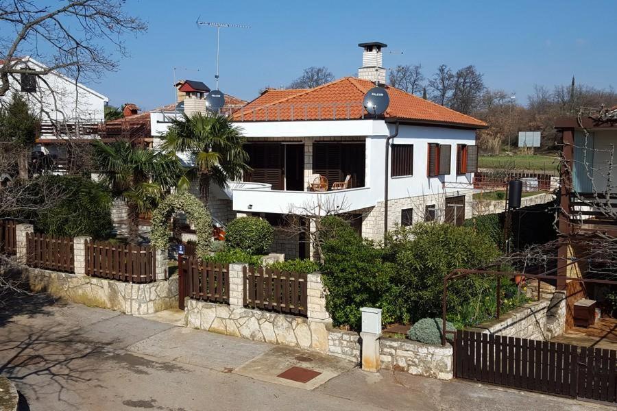 a white house with a fence in front of it at Apartment Alenka in Novigrad Istria