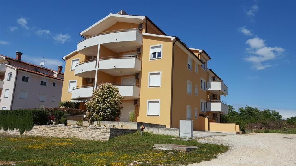 a large yellow building in front of a building at Apartment Nena in Novigrad Istria