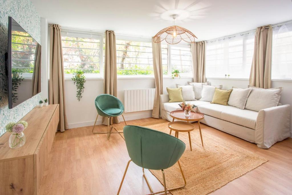 Cosy 7 Bedrooms with 3 bathrooms - Le Marais في باريس: غرفة معيشة مع أريكة بيضاء وكراسي