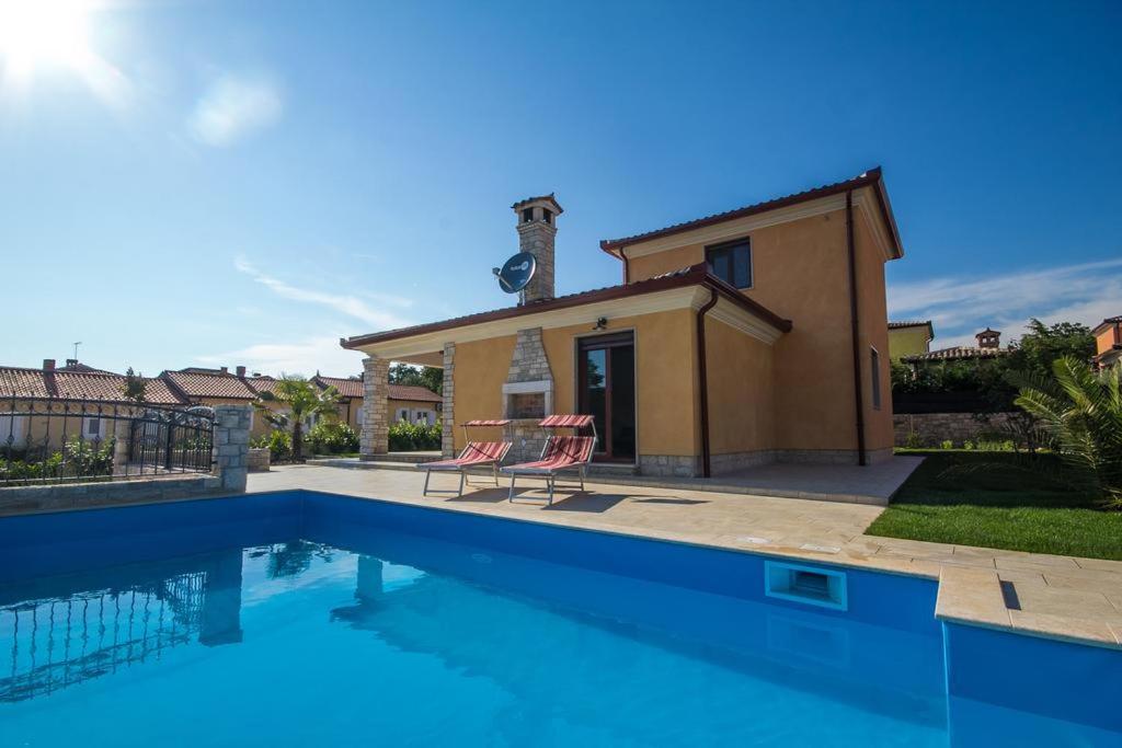 a villa with a swimming pool in front of a house at Villa Mateja in Karigador