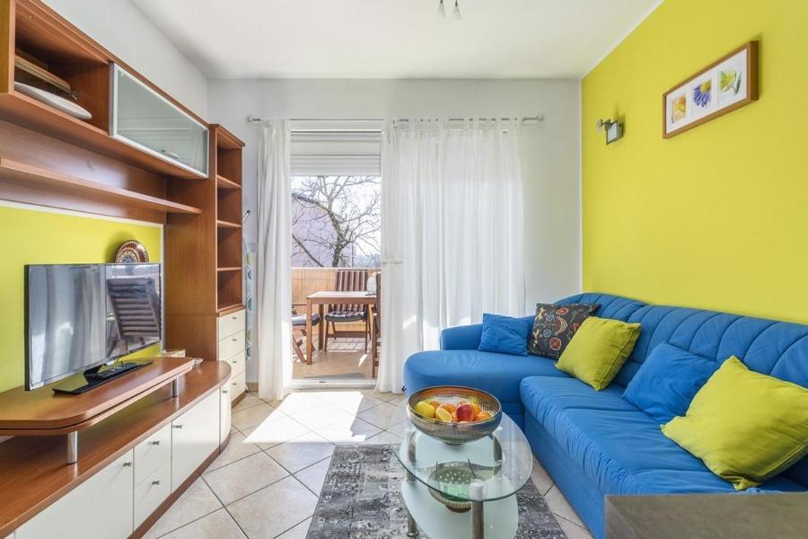 salon z niebieską kanapą i telewizorem w obiekcie Apartment Carigo w mieście Karigador