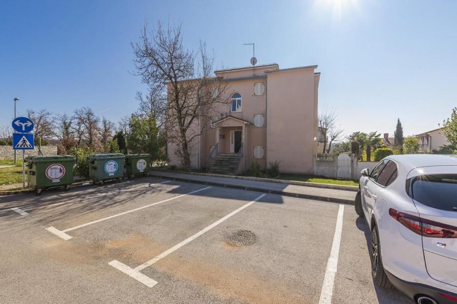samochód zaparkowany na parkingu przed budynkiem w obiekcie Apartment Carigo w mieście Karigador