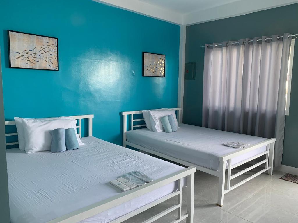 two beds in a room with blue walls at Oceano Con Vista Highland in Supa