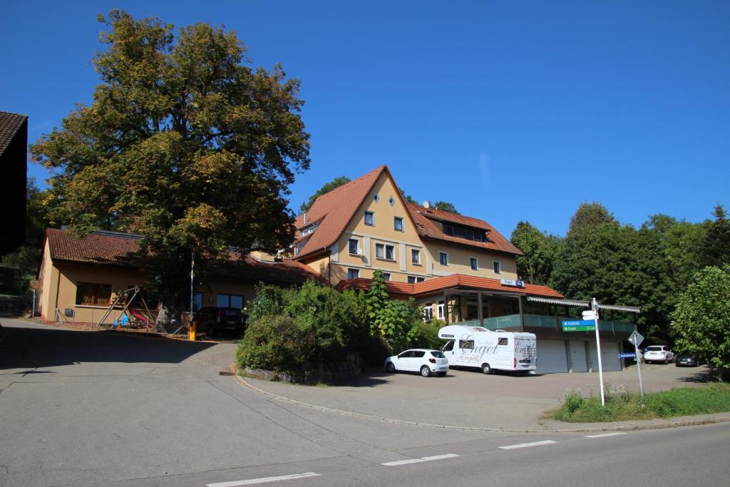 una piccola auto bianca parcheggiata di fronte a un edificio di Gasthaus Engel a Murg