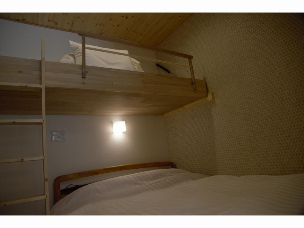 a small room with a bed and a bunk bed at Mountain Home Lodge in Deer Park in Nara