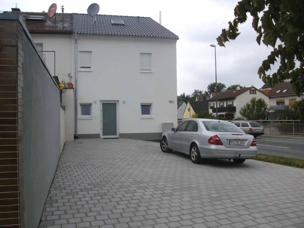 a car parked in front of a white house at Ferienhaus Nikita in Würzburg