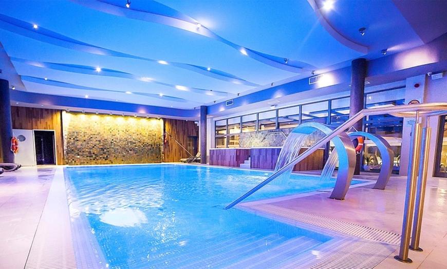 a indoor swimming pool with a water slide at Apartament na Klifowej in Niechorze