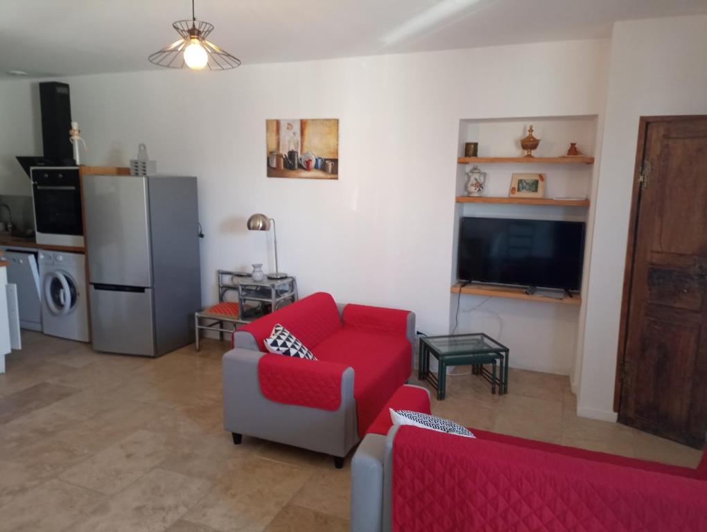 sala de estar con sofá rojo y TV en Casa Padulella (4 appartements), en Moriani Plage