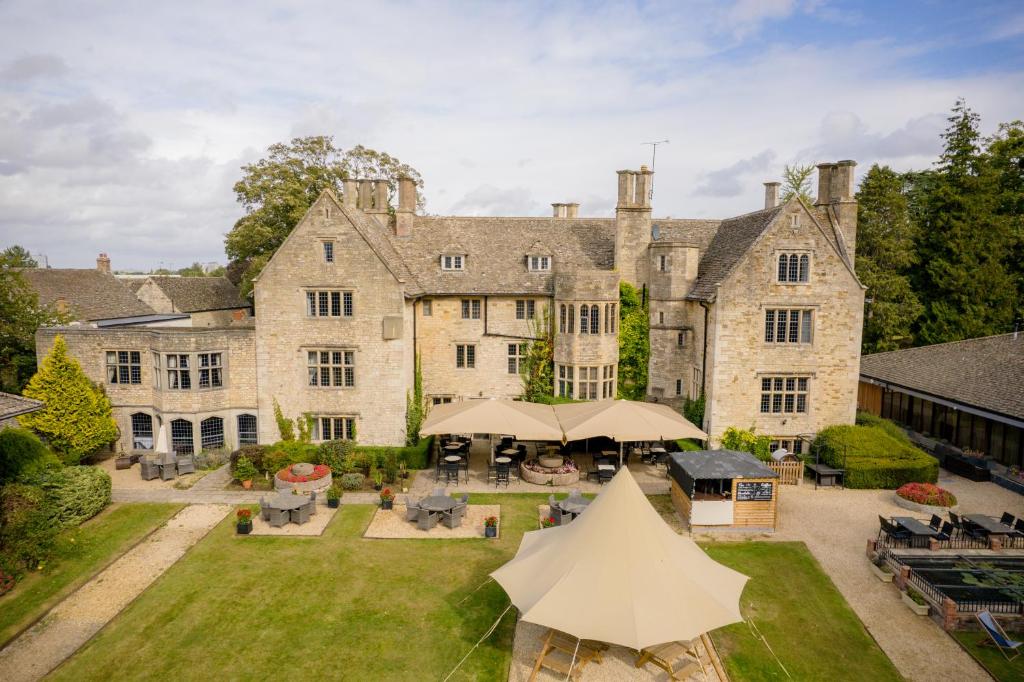 eine Luftansicht auf ein großes Steinhaus mit Hof in der Unterkunft Stonehouse Court Hotel - A Bespoke Hotel in Stroud