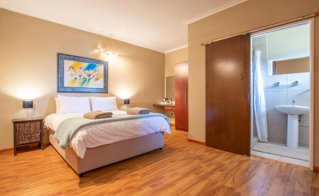 Un dormitorio con una cama y un baño con lavabo. en 50 Shades of Hay Guesthouse, en Atlantis